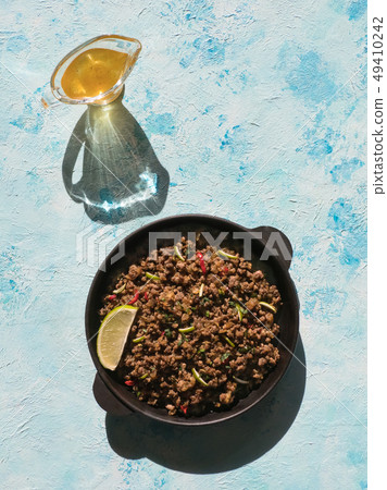 Indian minced meat Qeema on a sunny blue table. Indian minced meat Qeema on a sunny blue table. 49410242