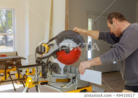 finishing work the worker cuts the wood moldings 49410817