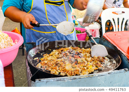 The seller is fried and cooking mussel can be seen The seller is fried and cooking mussel can be seen 49411763