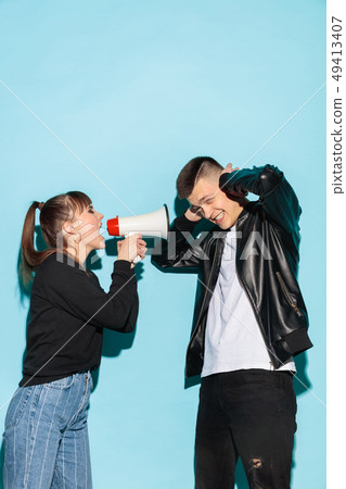 Portrait of young emotional female student with megaphone Portrait of young emotional female student with megaphone 49413407