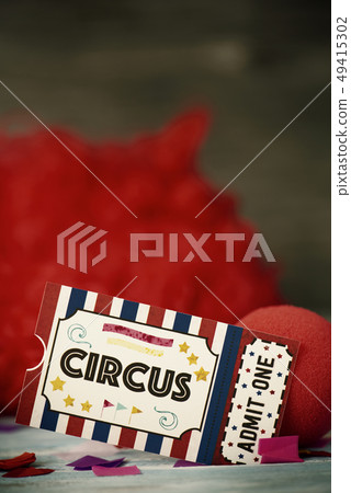 circus admission ticket, clown nose and red wig 49415302