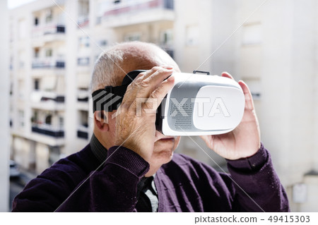 old caucasian man using a virtual reality headset old caucasian man using a virtual reality headset 49415303