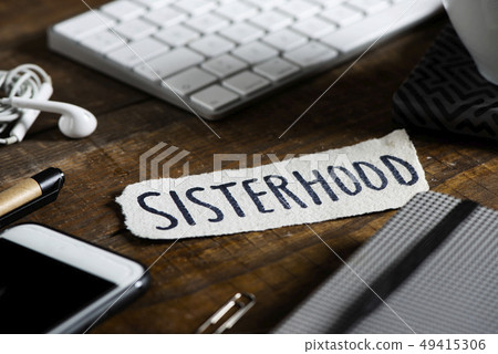 text sisterhood in a piece of paper on a table 49415306