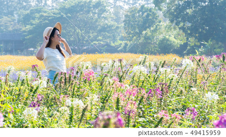 Asian women with blooming flower in the garden. 49415959