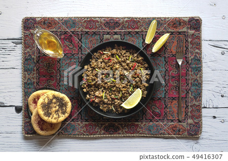 Indian minced meat Qeema on a white wooden table. Indian minced meat Qeema on a white wooden table. 49416307