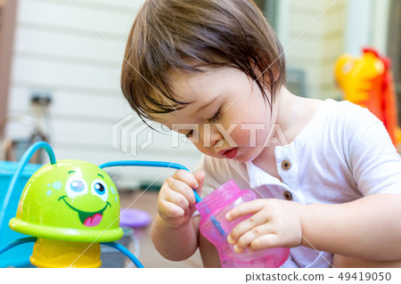 Toddler boy playing with a sprinkler 49419050