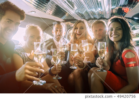 Group of party people in a limo drinking 49420756