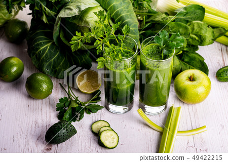 Green smoothie with fruits and vegetables on white wooden background. Green smoothie with fruits and vegetables on white wooden background. 49422215