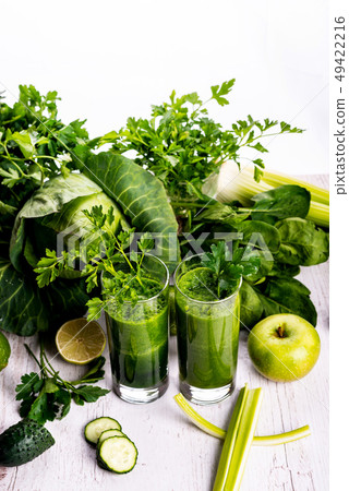Green smoothie with fruits and vegetables on white wooden background. Green smoothie with fruits and vegetables on white wooden background. 49422216
