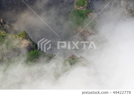 Mountain peak in dense clouds Mountain peak in dense clouds 49422779