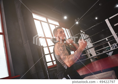Ready to fight. Muscular man in sports clothing training uppercut in boxing gym. Athlete male boxing Ready to fight. Muscular man in sports clothing training uppercut in boxing gym. Athlete male boxing 49422797