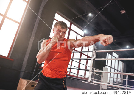 Float like a butterfly, sting like a bee. Focused muscular athlete in sports clothing keeping an Float like a butterfly, sting like a bee. Focused muscular athlete in sports clothing keeping an 49422819