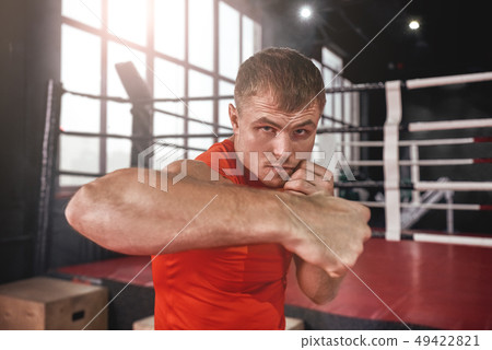Power hook - rough bruiser. Close-up of focused muscular athlete in sports clothing looking at Power hook - rough bruiser. Close-up of focused muscular athlete in sports clothing looking at 49422821