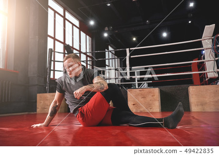 Warm up before training. Young muscular athlete in sports clothing warming up before training in Warm up before training. Young muscular athlete in sports clothing warming up before training in 49422835