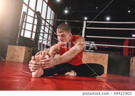 Warm up before training. Young muscular athlete in sports clothing warming up before training in Warm up before training. Young muscular athlete in sports clothing warming up before training in 49422903