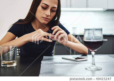 I should begin to be a friend to myself. Young woman sitting with a glass of red wine alone in 49423247