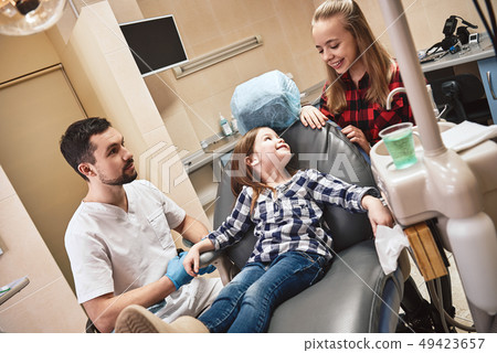 Premium Care. Personal Touch. Beautiful smiling little girl in dental office, waiting for dental 49423657