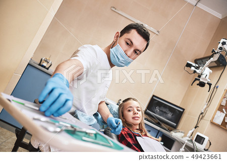 Advanced Medicine, Trusted Care. Teen at the dental office. Dentist treats teeth, girl lying in the 49423661