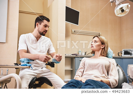 Keep your teeth bright and fresh. Dentist explains in detail the progress of the patient dental 49423683