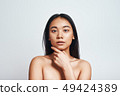 Perfect skin. Portrait of beautiful asian woman touching her skin and looking at camera while 49424389