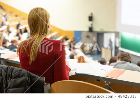 Audience in the lecture hall. Female student making notes. Audience in the lecture hall. Female student making notes. 49425315