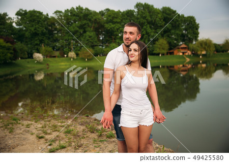 Couple in love hug each other near the lake 49425580