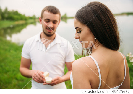 Man makes a marrige proposal to a girl. Gives her a ring for the engagement 49425622