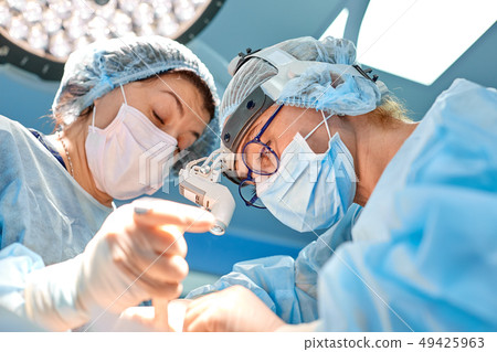 surgery, medicine and people concept - group of surgeons at operation in operating room at hospital 49425963