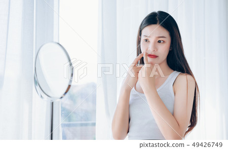 Young Asian woman squeeze acne problem face  49426749