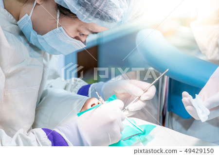 Asian dentist curing patient in dental clinic 49429150