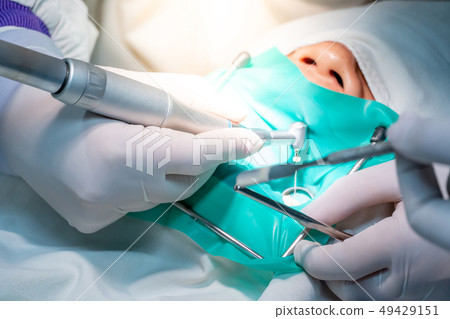 Dentist hand curing patient in dental clinic 49429151