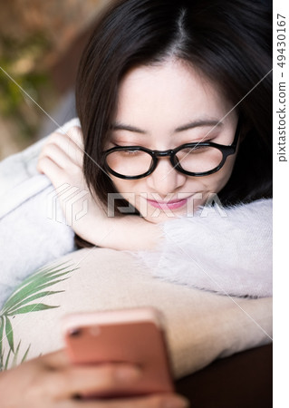 Woman looking at smartphone Woman looking at smartphone 49430167