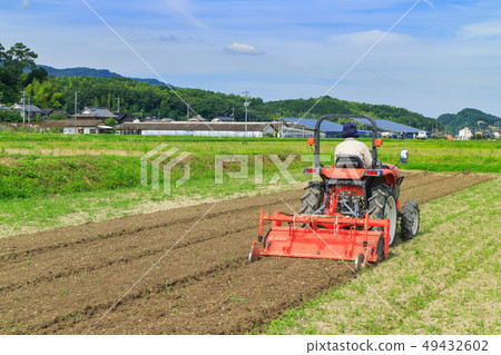 Farmer working on a tractor 49432602