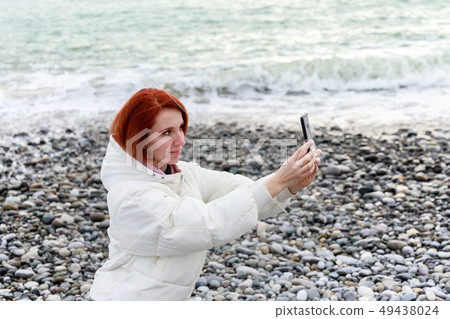 Young woman photographs herself on the phone Young woman photographs herself on the phone 49438024