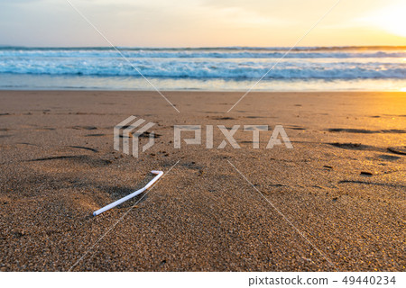 Plastic straw on a beach at sunset Plastic straw on a beach at sunset 49440234