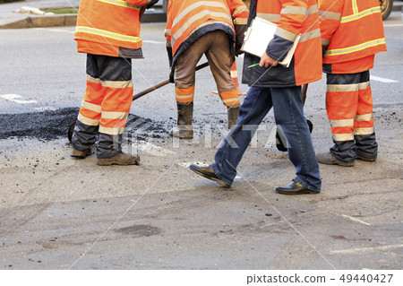 A team of road builders collect and align fresh 49440427