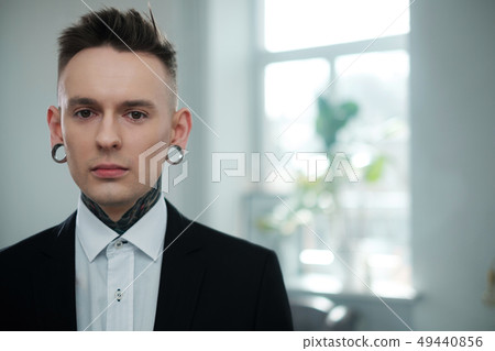 Portrait of alternative model with earplugs and tattoo Portrait of alternative model with earplugs and tattoo 49440856