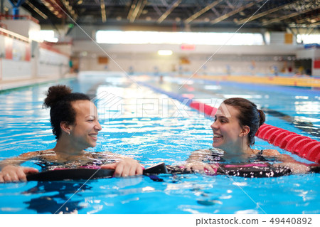 Multiracial couple attending water aerobics class in a swimming pool Multiracial couple attending water aerobics class in a swimming pool 49440892