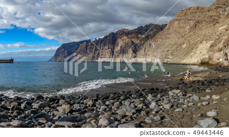 Guios beach with los gigantes cliffs and blurred tourists 49443446
