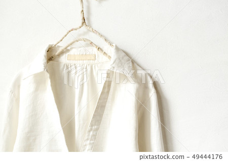 Upper body of a white hemp blouse on a hanger 49444176