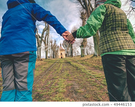 Couple tourists hold hands, walking in alley 49446153