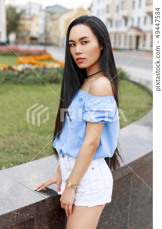 Beautiful young asian woman in a blouse and shorts Beautiful young asian woman in a blouse and shorts 49447584