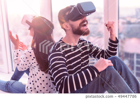 Pleased young man making fist while expressing gladness Pleased young man making fist while expressing gladness 49447786