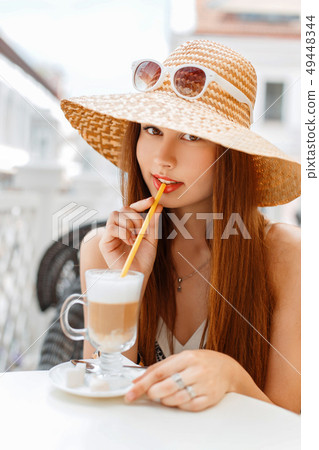 Beautiful elegant woman in a hat and sunglasses Beautiful elegant woman in a hat and sunglasses 49448344