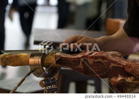 Hands while cutting spanish ham Hands while cutting spanish ham 49448814