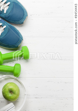 Fitness concept. Dumbbells, sneakers, headphones Fitness concept. Dumbbells, sneakers, headphones 49454443