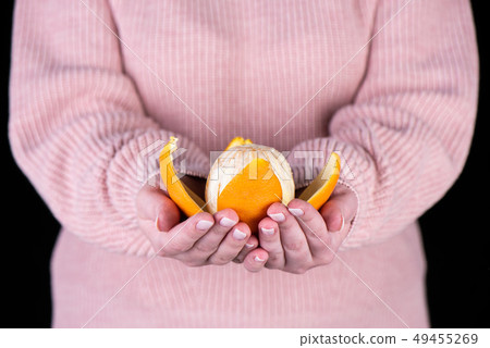Peeled orange on the palms of a girl 49455269