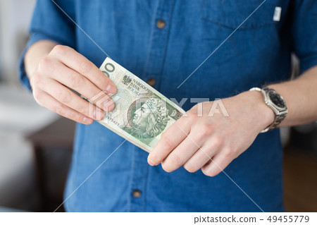 A rich man holding a lot of Polish money 49455779