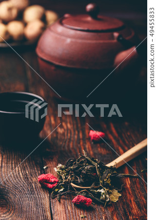Tea bowls with teapot and spoonful of raspberry 49455833