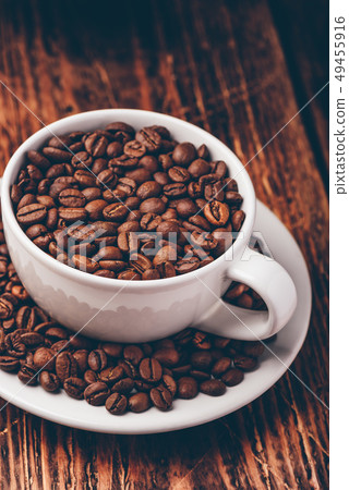 White cup full of roasted coffee beans White cup full of roasted coffee beans 49455916